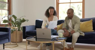 Kanepede oturup dizüstü bilgisayar kullanan ve evde konuşmaktan zevk alan mutlu çift. Yaşam tarzı, teknoloji, birliktelik, gezinme, bağlantı, eğlence