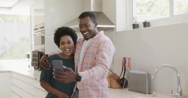 Video sohbeti, çeşitli çiftler modern mutfakta selfie çekiyorlar, gülümsüyorlar, evde anın tadını çıkarıyorlar. Yaşam tarzı, teknoloji, bağlanma, mutluluk, birliktelik, yurtiçi