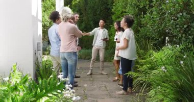 Çeşitli alıcılar Asyalı ajanları takip ediyor. Tabletle el sıkışıyorlar ve bahçe turu için el sıkışıyorlar. Peyzaj, müzakere, profesyonellik, açık hava, topluluk, işbirliği, modern