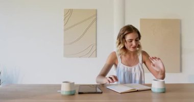 Genç çift evde, defterler ve kahve fincanlarıyla masada planlarını tartışıyor. İşbirliği, takım çalışması, beyin fırtınası, planlama, ortaklık, ilişki