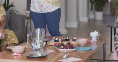 Bebek partisini kutluyoruz, çeşitli arkadaşlar gülüyor ve evde birlikte içki içiyoruz. Kutlama, arkadaşlık, toplanma, parti, mutluluk, annelik