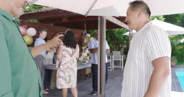 Şampanyayla kadeh kaldırma, çeşitli son sınıf arkadaşları havuz başında kutlama yapıyor. Kutlama, arkadaşlık, bahçe partisi, çeşitlilik, yaz, eğlence