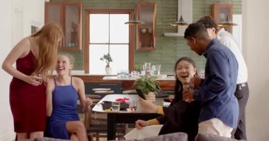 Çeşitli arkadaşlar mezuniyet törenini kutluyorlar. Mutfakta başarıya kadeh kaldırıyorlar. Kutlama, dostluk, başarı, tost, sosyal, canlı, mutluluk