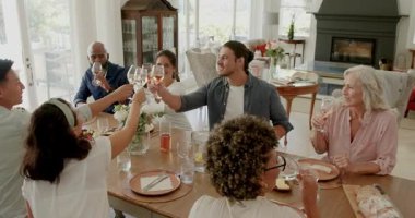 Çeşitli arkadaşlar ve aileler çiftlik evindeki masada gülüp kadeh tokuşturuyorlar. Kutlama, yoldaşlık, sosyalleşme, neşe, köy, neşe, neşe, neşe.