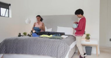 Çeşitli anne ve oğul yataklarına bavullarını hazırlıyor, evde tatil için hazırlanıyor, heyecanlı görünüyorlar. Seyahat, tatil, kaçamak, turizm