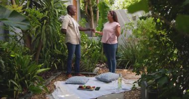 Çiçek değiş tokuşu, içten bir gülümseme, çeşitli çiftler bahçede piknik yapıyor. Romantizm, açık hava, doğa, aşk, şefkat, birliktelik