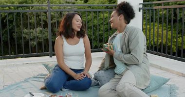 Çeşitli çiftler hediye sunuyor ve sürpriz partnerleri hasır sepetli balkon piknik battaniyesinde. Romantizm, kutlama, eğlence, coşku, sevgi, uyum, açık hava