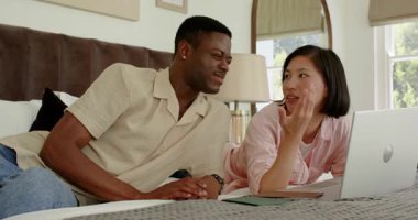 Yatakta dizüstü bilgisayarı işaret eden, çeşitli çiftler pasaport değiş tokuşu yapan ve detayları gördükten sonra gülümseyen. Romantizm, iletişim, samimiyet, seyahat, teknoloji, boş zaman, bağlantı