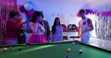 Bilardo masasına atılan bilardo topu ıskaladıktan sonra gülen farklı arkadaşlar, akıllı telefonlu maytapları çekiyorlar. Kutlama, dostluk, gece hayatı, eğlence, coşku, parti, birlik