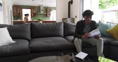 Afro-Amerikalı çift kanepe fotokopi odasında mektup açarak kutluyor. Modern, yaşam tarzı, samimi, samimi, neşeli, iletişim, iç mekan