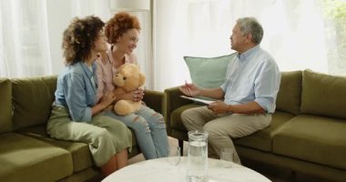 Aynı cinsiyetten lezbiyen çift evde rahat bir oturma odasında gülümseyip terapistle konuşuyor. danışmanlık, iletişim, ilişki, lgbtq, destek, terapi