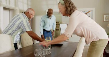 Çeşitli kıdemli arkadaşlar evde kutlama için hoş geldin tabelası hazırlıyorlar, yemek alanı hazırlıyorlar. Dekorasyon, toplantılar, konukseverlik, hazırlık, birliktelik