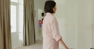 Çeşitli çiftler yatak odasına girip seyahat için kıyafet katlayan gömlek ve pantolonları bavula koyuyorlar. Ortaklık, birlikte yaşama, organizasyon, macera, yerli, uyum, rahatlama