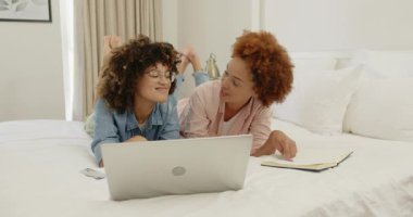 Evde dizüstü bilgisayar kullanırken gülümseyen eş cinsiyetli lezbiyen çift. LGBT, çeşitlilik, aşk, ilişki, teknoloji, mutluluk