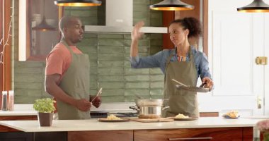 Çeşitli çiftler modern mutfakta birlikte yemek pişiriyor, evde lezzetli makarna yemekleri hazırlıyorlar. Mutfak, yemek hazırlama, takım çalışması, yemek, yaşam tarzı.
