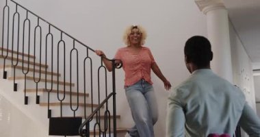 Çeşitli arkadaşlar evde sımsıkı sarılıyor, ellerinde çiçekler, neşe ve dostluk ifade ediyorlar. Kutlama, mutluluk, birliktelik, sıcaklık, duygu, toplanma