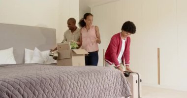 Çeşitli aileler yeni bir ev macerasına hazırlanmak için bavullarını ve kutularını yatak odasına boşaltıyor. Taşınma, taşınma, yaşam tarzı, yolculuk