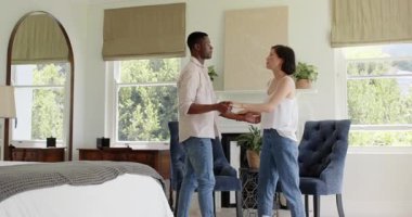 El ele tutuşan, Afrikalı Amerikalı erkek ve Asyalı kadın sallanıyor, dönüyor, sarılıyor yatak odasında. Romantik, samimiyet, bağlantı, uyum, zarafet, sıcaklık, rahatlık.