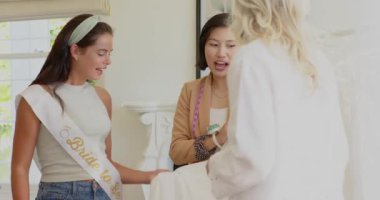 Gelinin kuşak giyip eve girmesi terzi kadın ve arkadaşının geceliği kaldırması, fotokopi odası. Düğün, kutlama, zarafet, zanaat, moda, beklenti, kadınlık