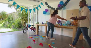 Doğum günü partisi için dekorasyon masası, evde çeşitli çiftler balon hazırlıyor. Kutlama, şenlik, hazırlık, dekorasyon, çeşitli aile, neşe