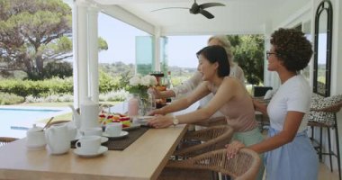 Çeşitli bayan arkadaşlar gün ışığına tepki veriyor, minyon dörtlü servis ediyor, verandaya bilardo meyve suyu döküyorlar. Arkadaşlık, açık hava, rahatlık, zarafet, kutlama, sıcak, kırsal