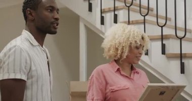 Gülümseyen farklı arkadaşlar evde merdivenlerin yanında sohbet ediyorlar, birlikte mutlular. Mutluluk, toplanma, ev hayatı, birliktelik, dostluk.