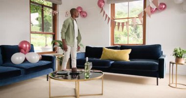 Adam evde balonlar ve pastayla kutlamaya hazırlanıyor. Parti, şenlik, dekorasyon, pişirme, konukseverlik, vesile