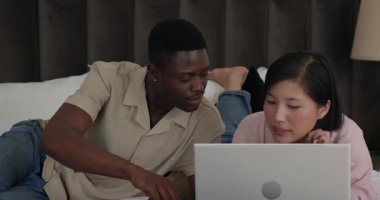 Tablet kredi kartı tutan adam ödeme bilgilerini doğrularken farklı çiftler yatakta göz teması kuruyor. Romantik, işbirliği, teknoloji, samimiyet, boş zaman, bağlantı, gelişigüzel