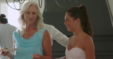 Çeşitli arkadaşlar, olgun bir adamın salonda meyve ikram edip dans etmesine tepki veriyor. Kutlama, dostluk, neşe, sosyalleşme, yaşam tarzı, iç mekan, yoldaşlık