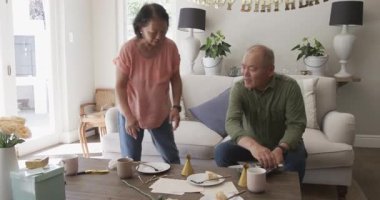 Kıdemli kadın evde doğum günü süslemeleri hazırlıyor, masayı özenle düzenliyor. Kutlama, parti, şenlik, yaşlılık, yaşam tarzı, etkinlik