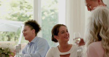 Çeşitli arkadaşlar masada selamlaşır, gül kadehleri tokuşturur, kıvırcık saçlı adamın hikâyesini dinlerler. Kutlama, sosyalleşme, arkadaşlık, sıcak, zarif, açık hava, kırsal