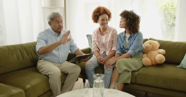 Yaşlı bir adam, evdeki kanepede eşcinsel lezbiyen çiftlerle tartışıyor. üst düzey, sohbet, kağıt işleri, yerli, çeşitlilik, tartışma