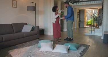 Erkek, evde kadına evlenme teklif ediyor, ikisi de mutlu ve şaşırmış görünüyor. Nişan, evlenme teklifi, aşk, romantizm, farklı çiftler, duygu