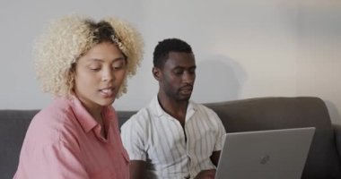 Farklı çiftler kanepede oturup dizüstü bilgisayardan bir şeyler izliyorlar. Yaşam tarzı, eğlence, bağlanma, teknoloji, birliktelik, rahatlama.