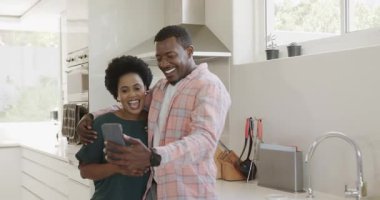 Video sohbetleri, selfie çekmeler, mutfakta gülümseyen çeşitli arkadaşlar, evde birlikte eğlenmeler. Arkadaşlık, yaşam tarzı, teknoloji, mutluluk, akıllı telefon, bağlanma