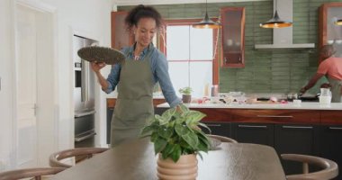 Mutfakta peçetelerle sofra kuran bir kadın, evde çeşitli aile kutlamalarına hazırlanıyor. Hazırlık, yemek, sofra takımı, konukseverlik, şenlik, vesile