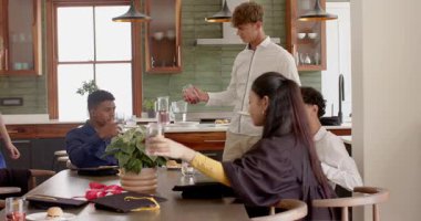 Beyaz gömlekli adam kaydırak servisi yapıyor, meyve suyu içiyor arkadaşları adaya taşınıyor ve kadeh kaldırıyor. Kutlama, dostluk, evcil, gayri resmi, samimi, yaşam tarzı, modern