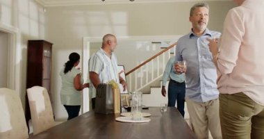 Evde kutlama yapan, içki içen ve sohbet eden bir grup son sınıf öğrencisi. Yaşlılar, kutlama, sosyalleşme, arkadaşlık, topluluk, toplanma