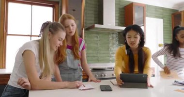 Mutfakta toplanan farklı arkadaşlar notları dizüstü bilgisayar kullanarak ve tezahürat yaparak gözden geçiriyorlar. İşbirliği, takım çalışması, yenilik, topluluk, gündelik, modern, çeşitlilik