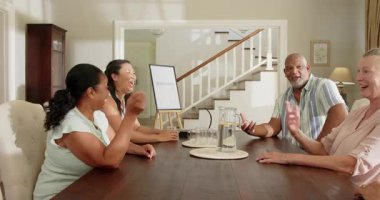 Masada oturan kıdemli adam, evdeki çeşitli gruplarla tartışmalara öncülük ediyor. Toplantı, takım çalışması, işbirliği, liderlik, çeşitlilik, beyin fırtınası