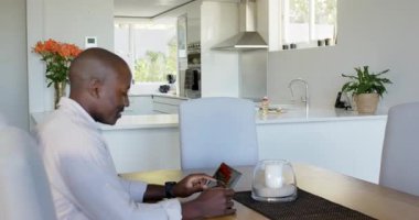 Sırt çantalı Afro-Amerikan baba ve oğlu annelerinin evde yaptığı gibi kahvaltı yapıyorlar. Çeşitli aile, sabah rutini, ebeveynlik, bağlanma, mutfak, ev hayatı