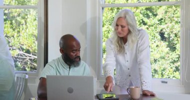 Dokunmayla tetiklenen, çeşitli yaşlı çiftler tablet kullanarak mavi kumaşı seçiyorlar. İşbirliği, teknoloji, yaşam tarzı, modern, konfor, iletişim, uyum