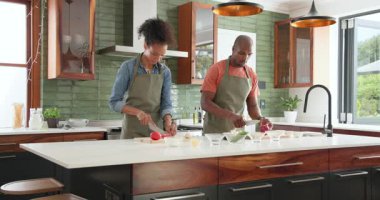 Çeşitli çiftler modern mutfakta birlikte taze sebzeler hazırlıyor, evde yemek pişirmenin tadını çıkarıyorlar. Mutfak, ev hayatı, sağlıklı beslenme, yemek hazırlama, yaşam tarzı, takım çalışması.