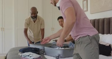 Yolculuğa hazırlanan çeşitli erkek arkadaşlar yatağa gümüş bavul koyup pasaportlarını kontrol ediyorlar. Macera, seyahat, arkadaşlık, paketleme, organizasyon, keşif, gündelik