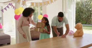 Çeşitli aileler doğum günlerini evde hediyeler ve balonlarla kutluyor, neşeli hissediyorlar. Kutlama, mutluluk, parti, hediyeler, birliktelik