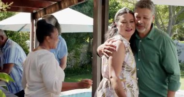 Arka bahçede kutlama yapan, gülümseyen ve güneşli bahçede selfie çeken farklı kıdemli arkadaşlar. Mutluluk, bağ, güneş ışığı, birliktelik, neşe