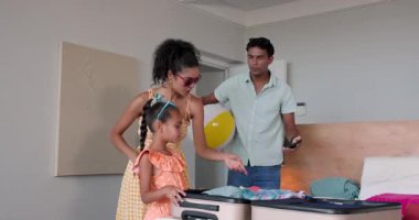 Çeşitli aile planlaması, iyi aydınlatılmış bir evde ilk tatil, selfie çekmek ve plaj topu tutmak. Tatil, macera, hazırlık, birliktelik, neşe, eğlence, aile