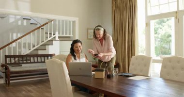 Kıdemli kadın ve arkadaş evde hediyeyle kutlama yapıyorlar, gülümsüyorlar ve neşeliler. Kutlama, dostluk, mutluluk, hediye, yaşlılık, arkadaşlık