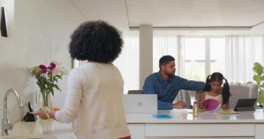 Çeşitli aileler mutfak tezgahında dizüstü bilgisayar ve okul malzemeleriyle ev ödevlerini tartışıyor. eğitim, öğrenim