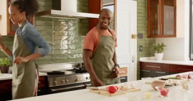 Çeşitli çiftler mutfakta birlikte yemek pişiriyor, dans ediyor ve evde yemek hazırlıyor. Aşk, ilişki, yaşam tarzı, ev hayatı